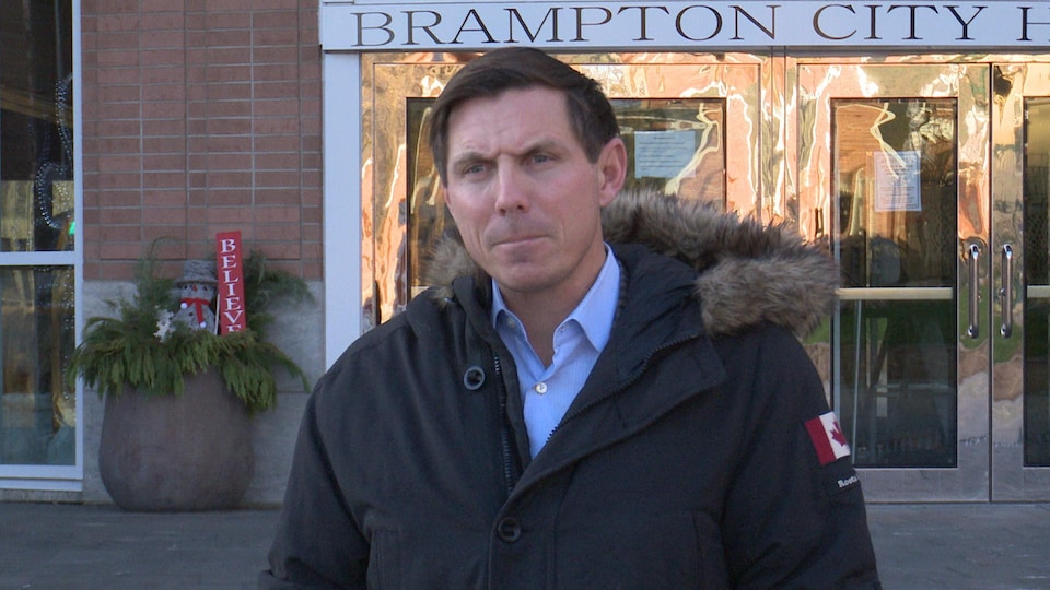 Patrick Brown outside Brampton City Hall answers questions from a reporter. 