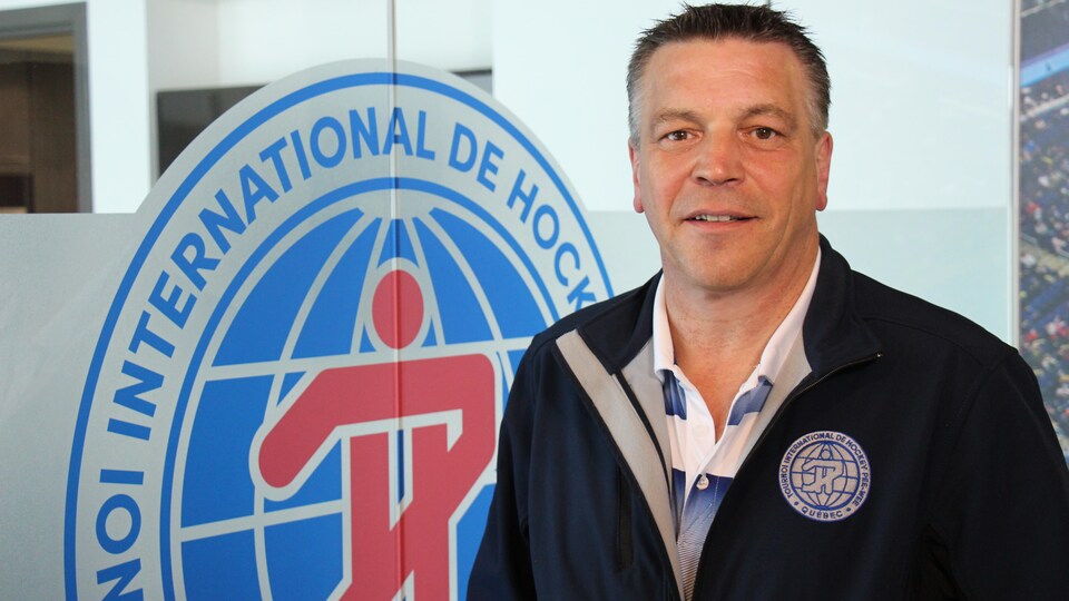 Il pose devant un logo du tournoi