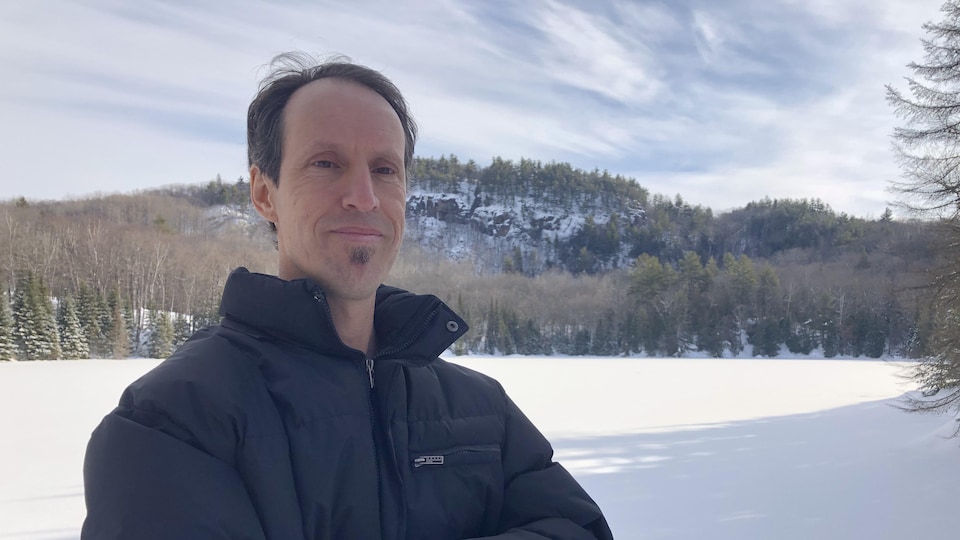 Patrick Gravel, de la Coopérative de solidarité des forêts et des gens, devant un lac gelé.