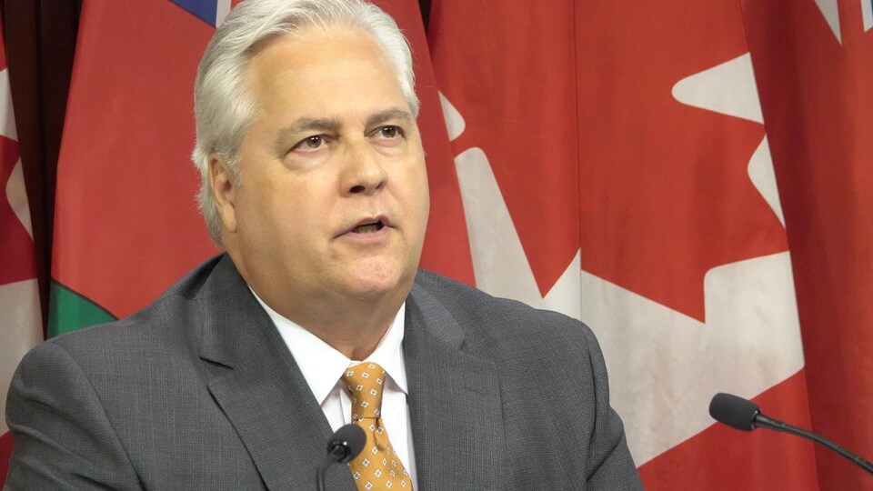 Paul Dubé devant les micros du studio des médias de l'Assemblée législative de l'Ontario.