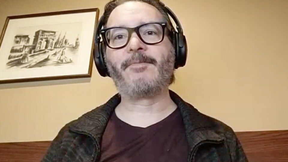 Un homme avec des écouteurs sur la tête fait une entrevue Skype. 