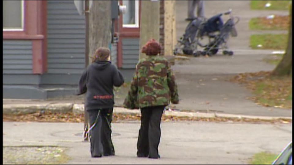 Deux enfants traversent la rue dans un quartier pauvre de Saint-Jean au Nouveau-Brunswick.