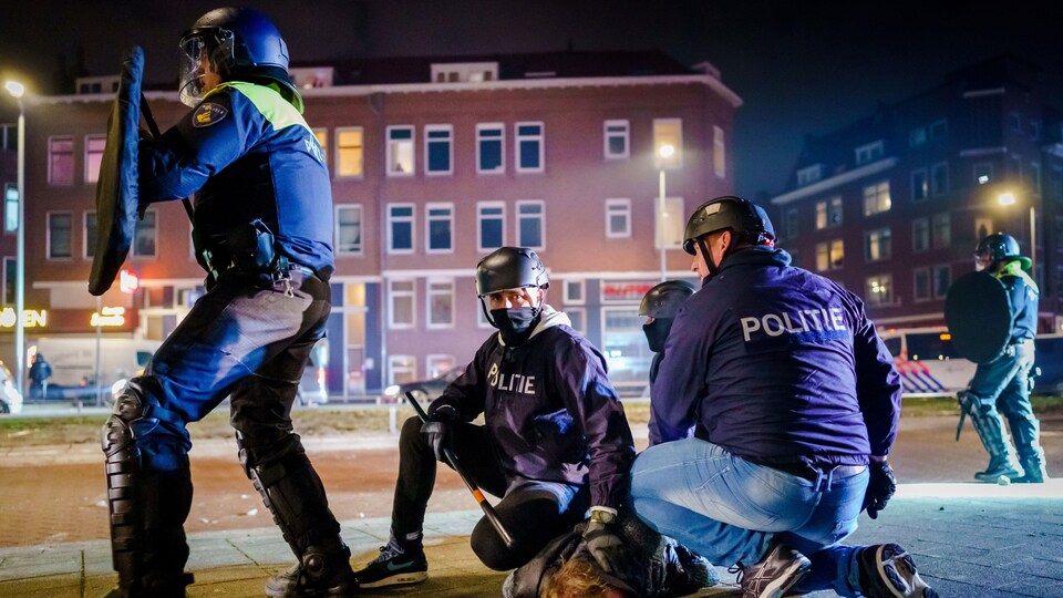 Des policiers arrêtent un homme.