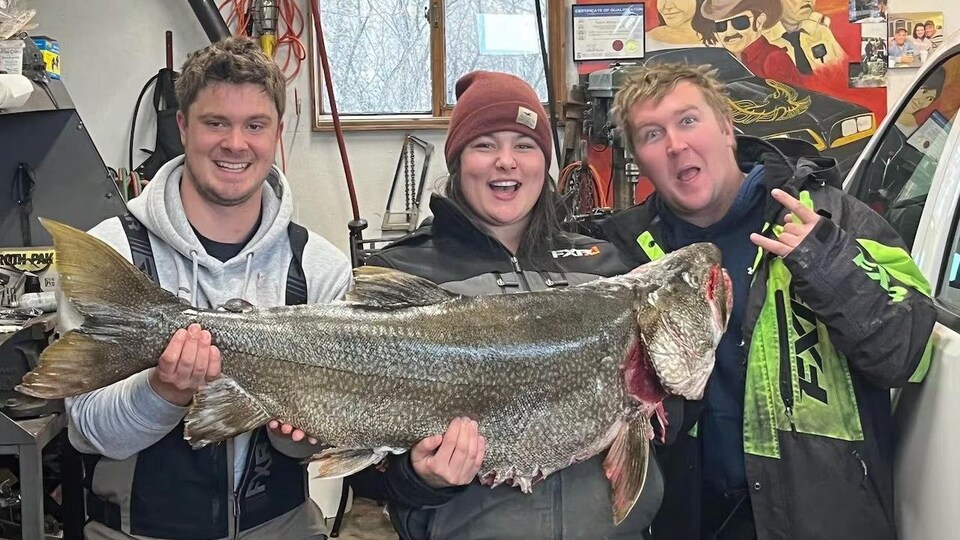 Brad Sadkosky, Sam Boucha et Brad Molloy tenant un poisson.