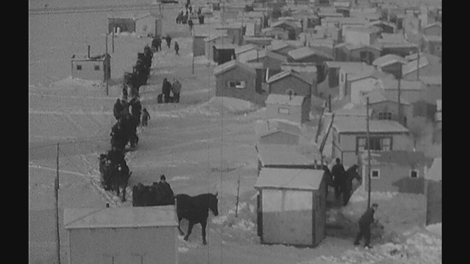 Un village de pêche avec des traineaux tirés par des chevaux.