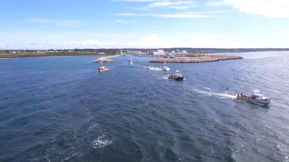Photo prise par drone de bateaux de pêche s'éloignant du quai.