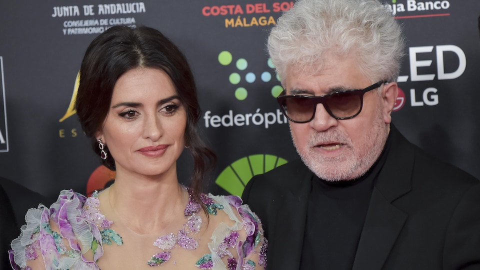 Pedro Almodovar et Penélope Cruz esquissent un sourire en posant pour les photographes sur un tapis rouge.