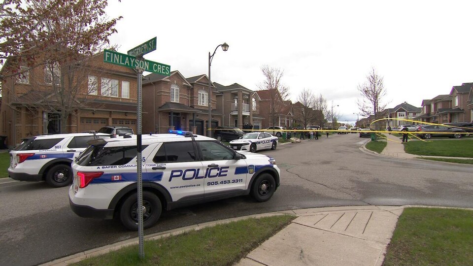 Trois véhicules de police bloquent la rue où l'enfant mort a été trouvé.