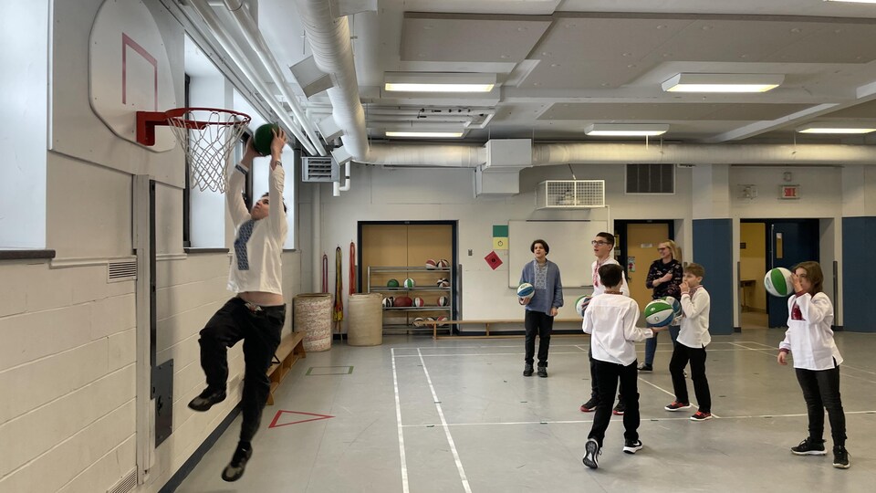 Des jeunes jouent au basket.