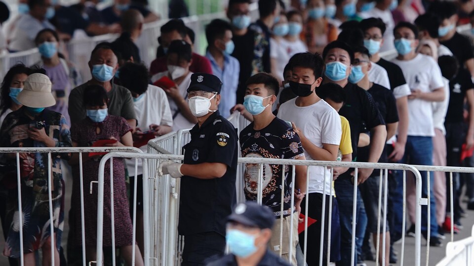Des personnes font la queue pour un test de COVID-19 à Pékin.
