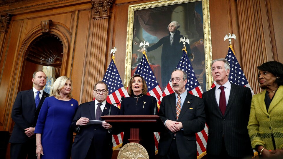 Nancy Pelosi, devant un portrait du président George Washington, entourée de six leaders démocrates.