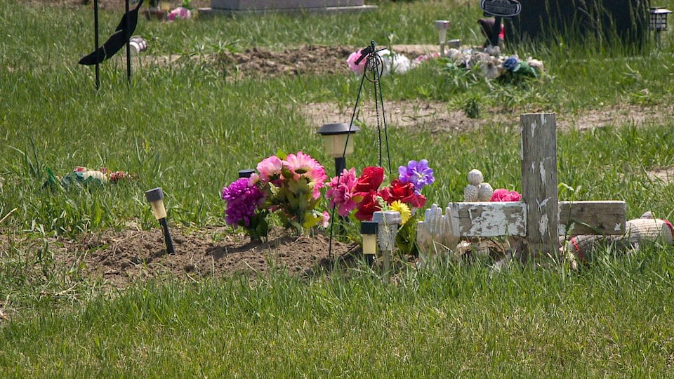 Des fleurs sur la pelouse près d'une croix blanche (archives).