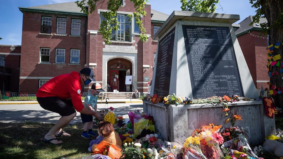 People lay flowers in front of a monument to former Native residents in Kamloops.