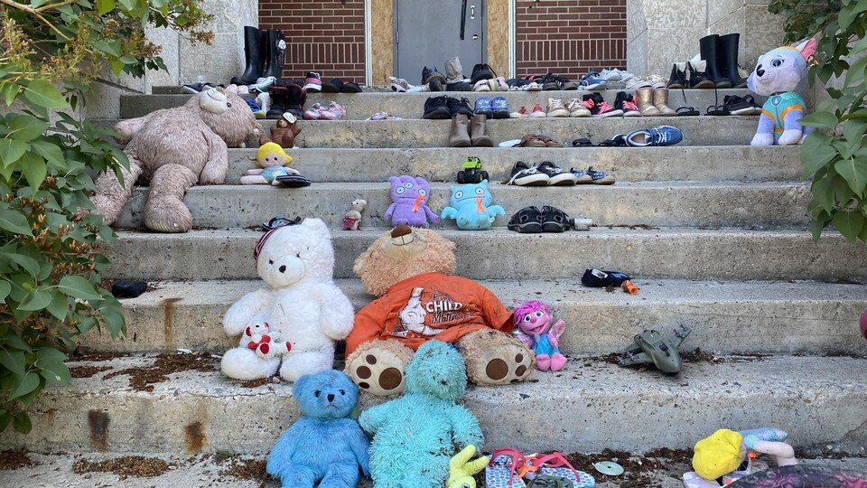 Des oursons en peluche et des souliers sur des marches.