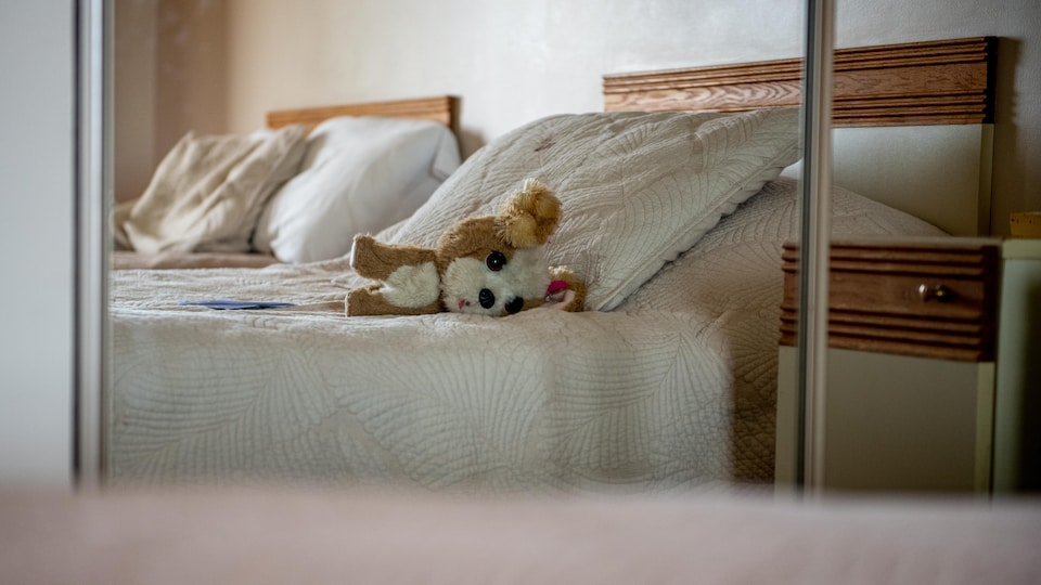 une peluche sur un lit dans un hotel.