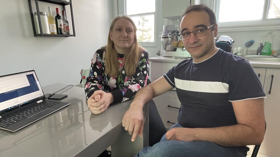 Marina et Carlos Pires sont assis à une table, dans la cuisine d'un logement. 