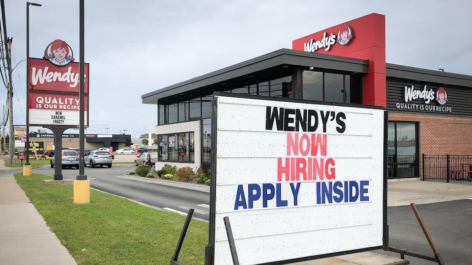 Une affiche devant un restaurant Wendy's invite les gens à postuler à un emploi.