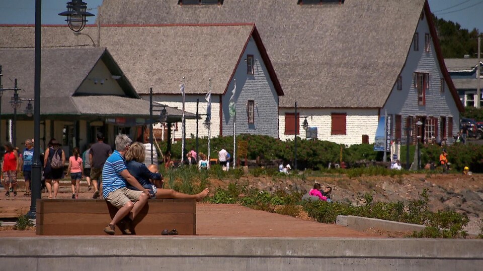 Des touristes se reposent près de la promenade de Percé.