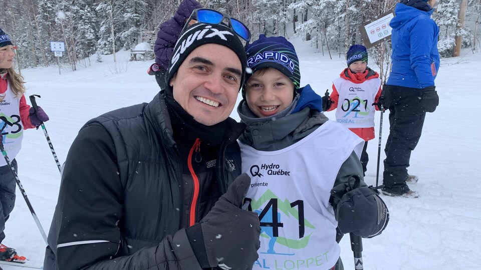 Dominic Duret et un de ses fils souriant devant la piste de ski de fond.