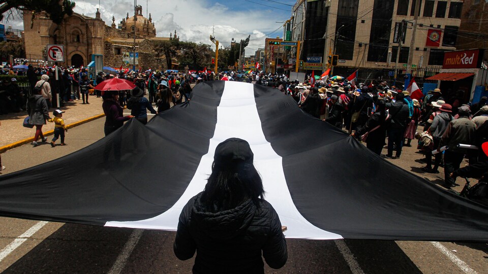 Des manifestants portant un énorme drapeau.