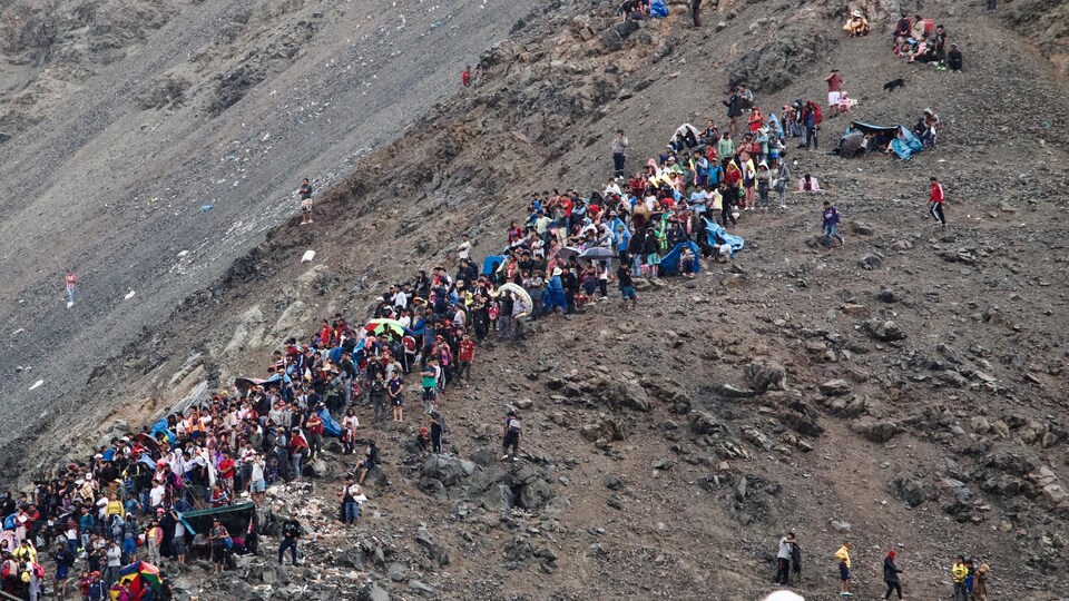 Une vue aérienne montre des personnes regardant près d'un glissement de terrain causé par de fortes pluies, à Arequipa, au Pérou, le 6 février 2023.