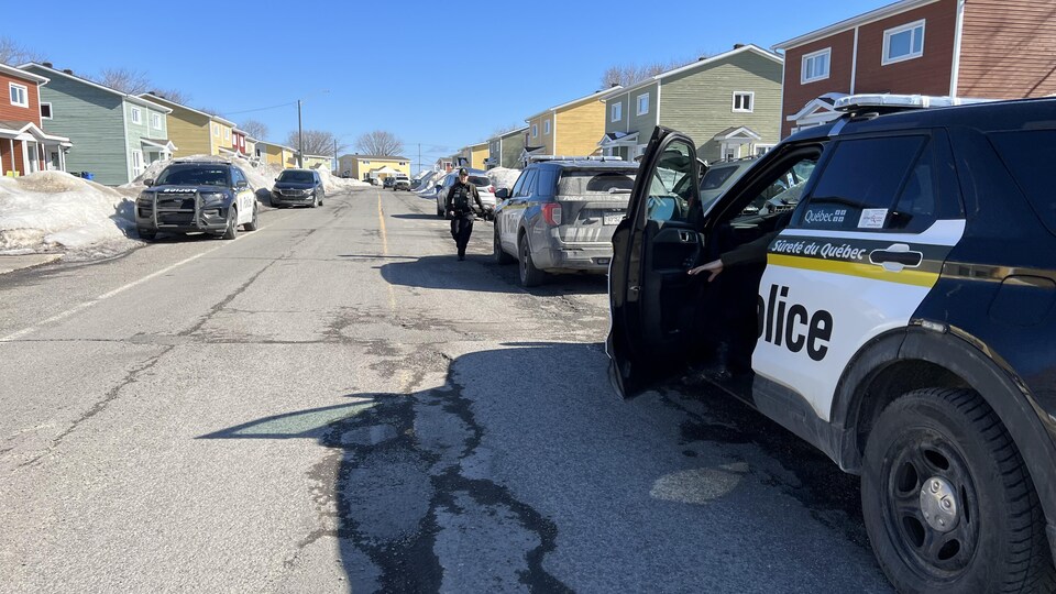 Policiers et voiture de la SQ sur une rue résidentielle de Matane.
