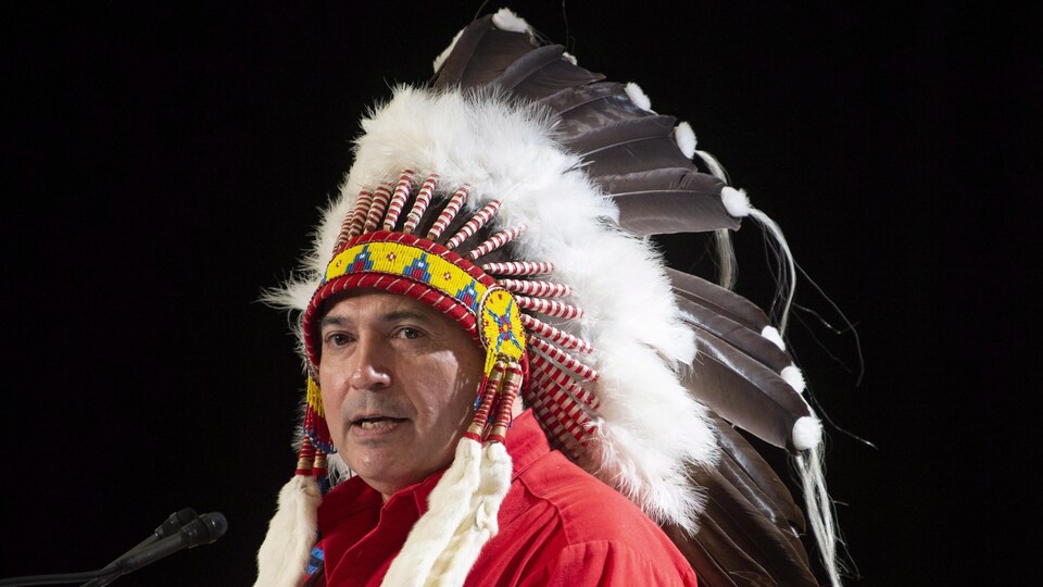 M. Bellegarde porte une coiffe traditionnelle à plumes.