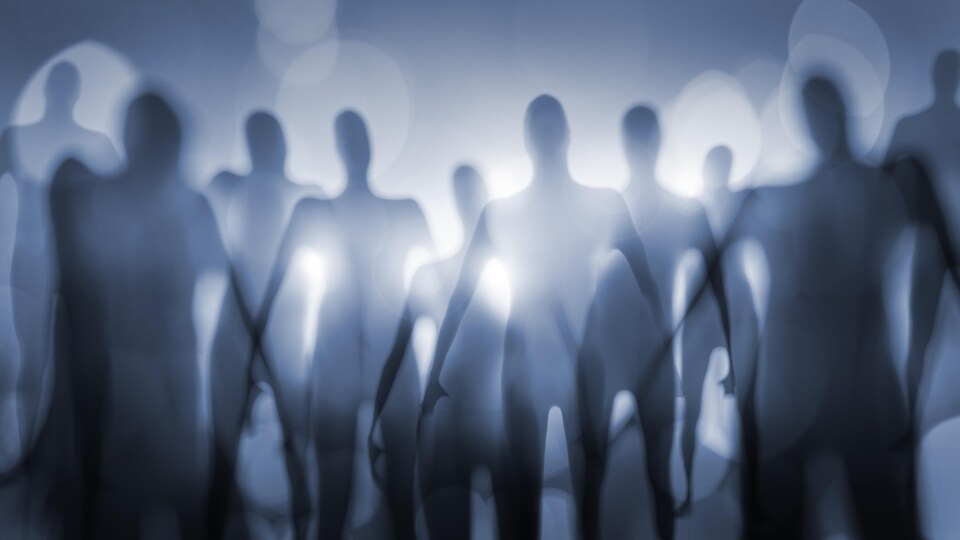 Des silhouettes floues de plusieurs personnes.