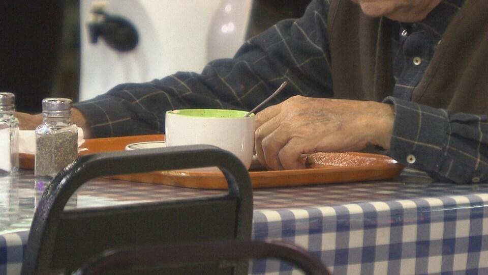 Un homme prend un repas dans une soupe populaire