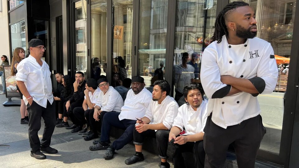 Le personnel d'un restaurant attend, sur le trottoir, la fin de la panne.