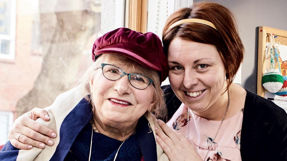 Une dame plus vieille est posée en compagnie d'une jeune femme.