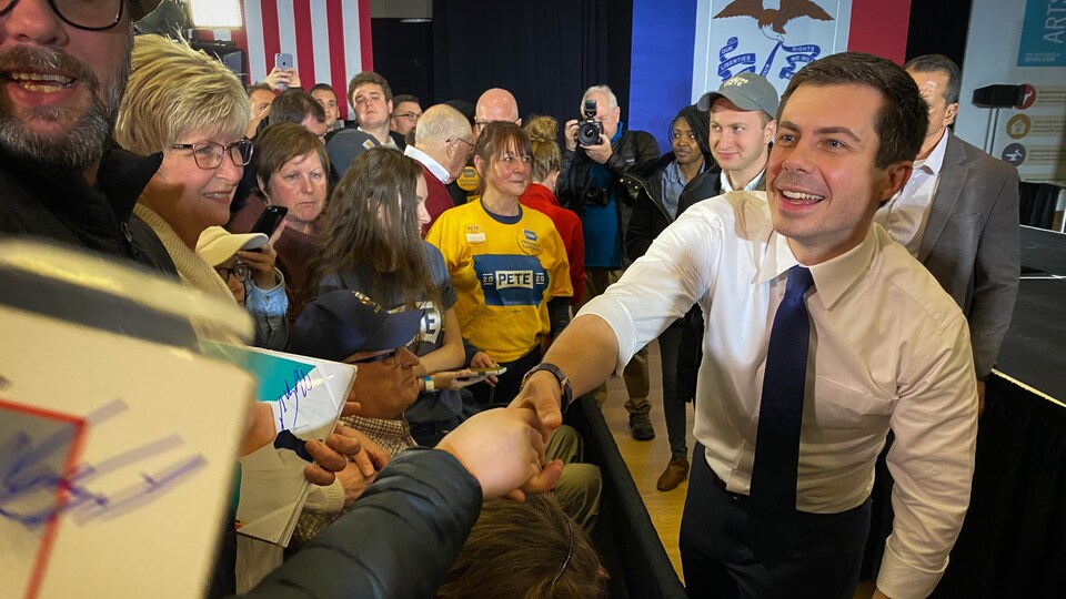 Un politicien serre la main de ses partisans.