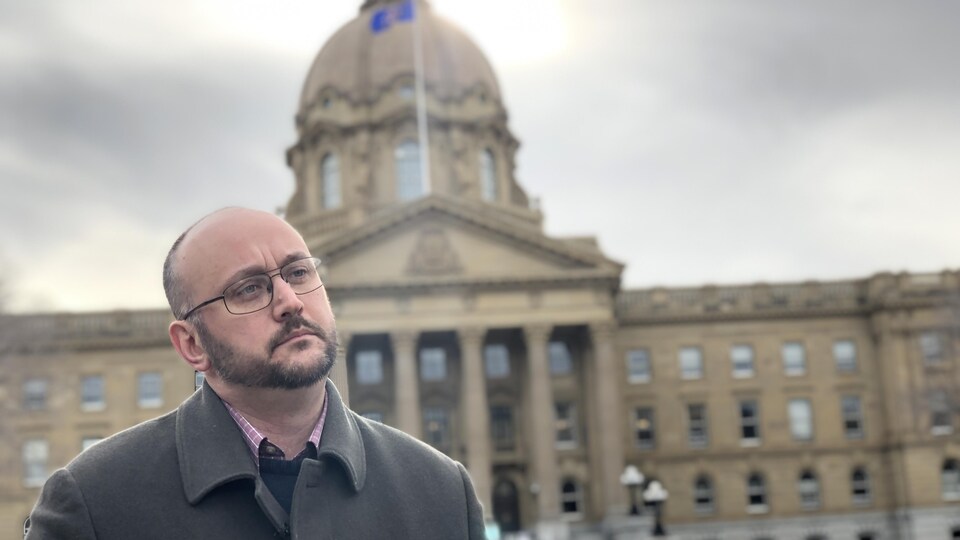 Peter Downing regarde au loin. Il pose devant l'Assemblée législative provinciale à Edmonton. 