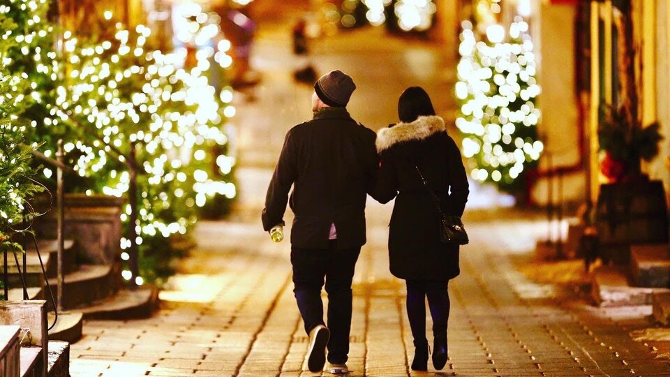 Un couple déambule dans le Petit Champlain à l'aube de Noël, à Québec.