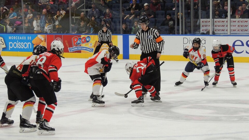 Un arbitre procède à une mise au jeu lors d'un match disputé dans le cadre du 58e Tournoi international de hockey pee-wee en 2017.