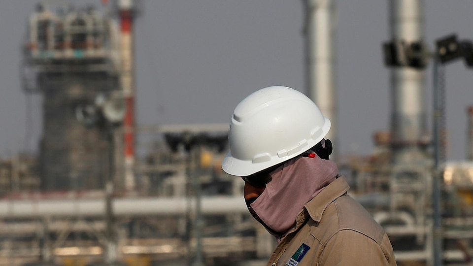 Un travailleur marche devant le complexe pétrolier d'Abqaiq en Arabie saoudite