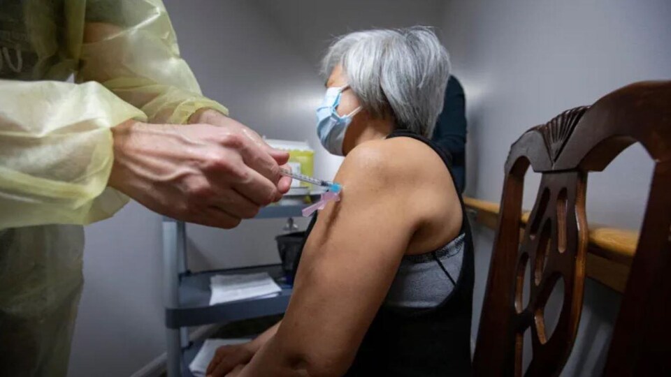 Une personne âgée reçoit sa première dose du vaccin.