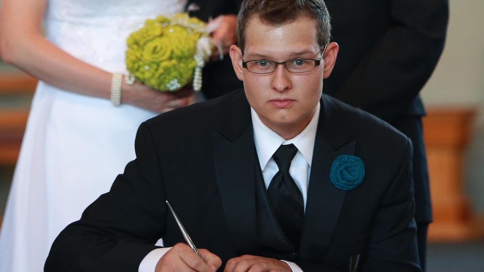 Philip Chicoine signe un document lors du mariage de son frère.