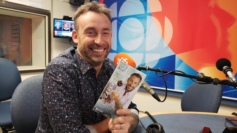 Philippe Lapeyrie, en studio, tient son nouveau guide des vins.