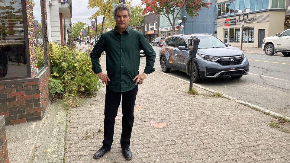 Philippe Marquis pose devant l'Abstracto, les mains sur les hanches, souriant.