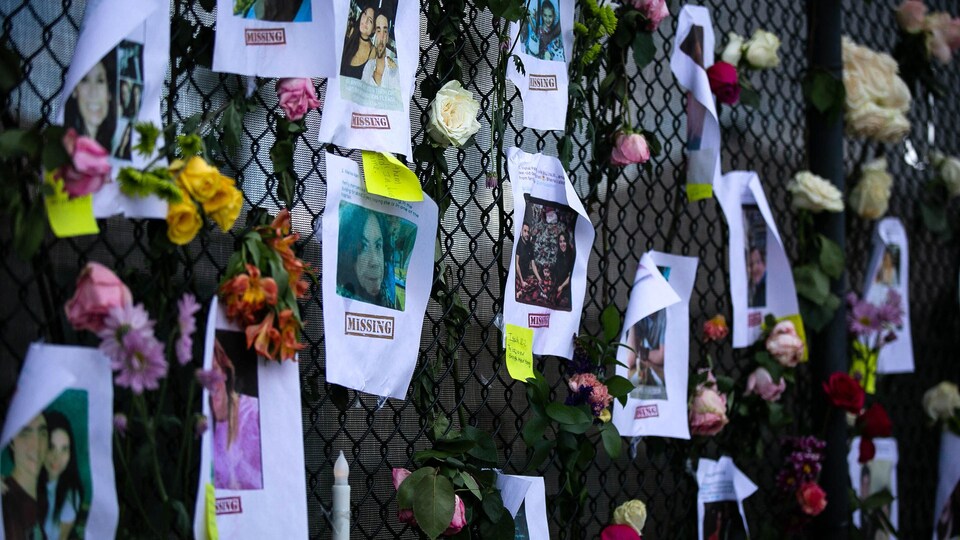 Des photos de personnes disparues sur une clôture, le 26 juin 2021.