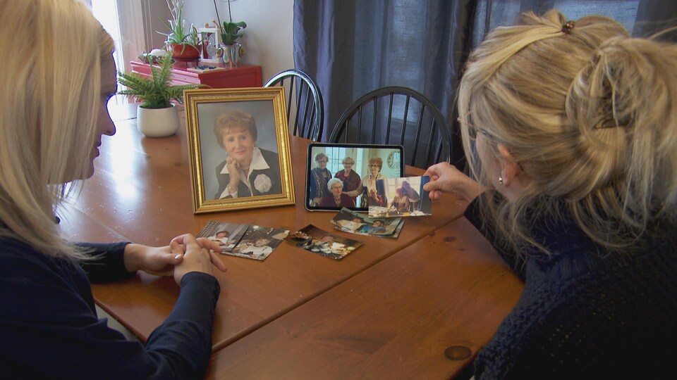 La journaliste et Brigitte Dandurand regardent des photos de Solange Riendeau.