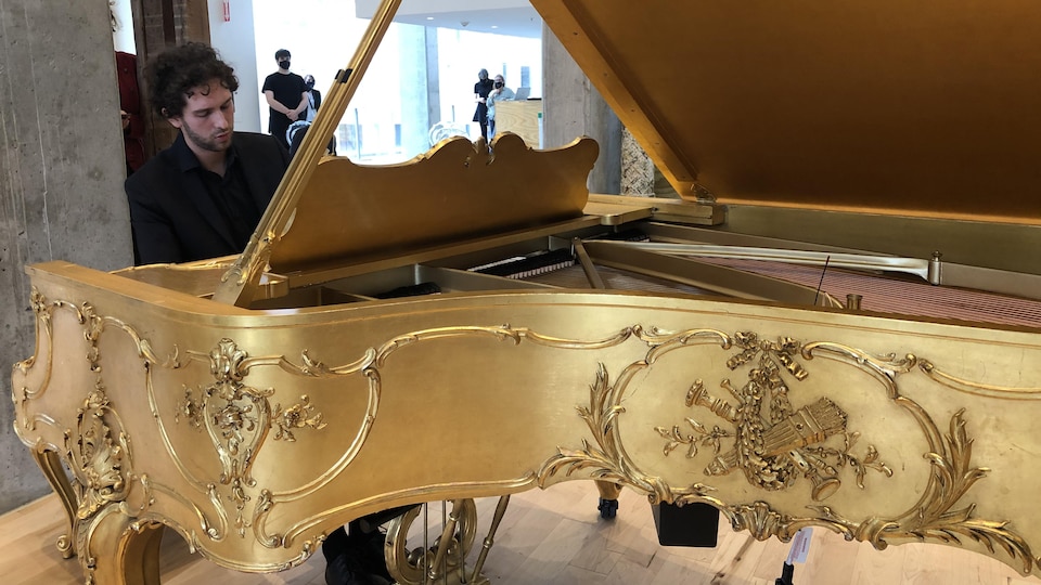 Le pianiste Samuel Blanchette-Gagnon interprète une pièce de Robert Schumann sur le piano recouvert d'or installé dans le foyer du Diamant.