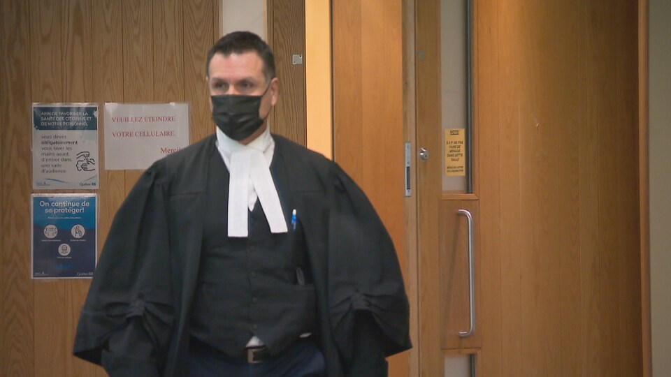 Wearing a gown, he exited the courtroom