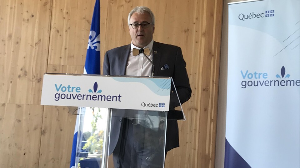 Pierre Dufour parle au micro derrière un lutrin du gouvernement du Québec.
