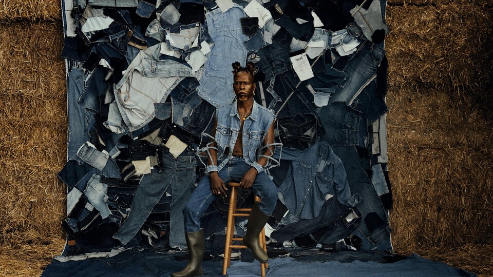 Actors wearing head to toe jeans sat in front of a collage of denim scraps and haystacks.
