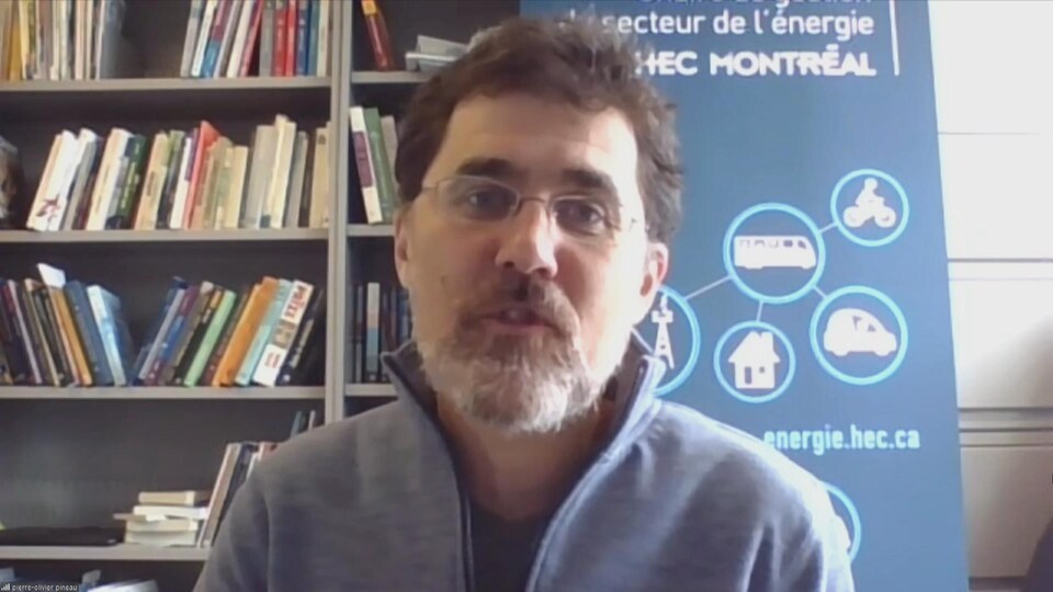 Pierre-Olivier Pineau devant une bibliothèque.