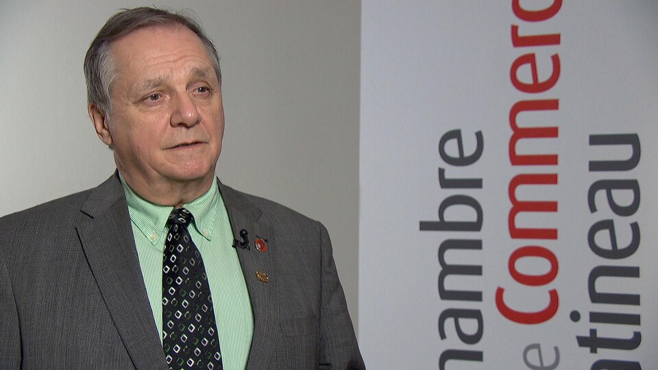 Pierre Samson en entrevue devant une bannière comportant le logo de l'organisme.