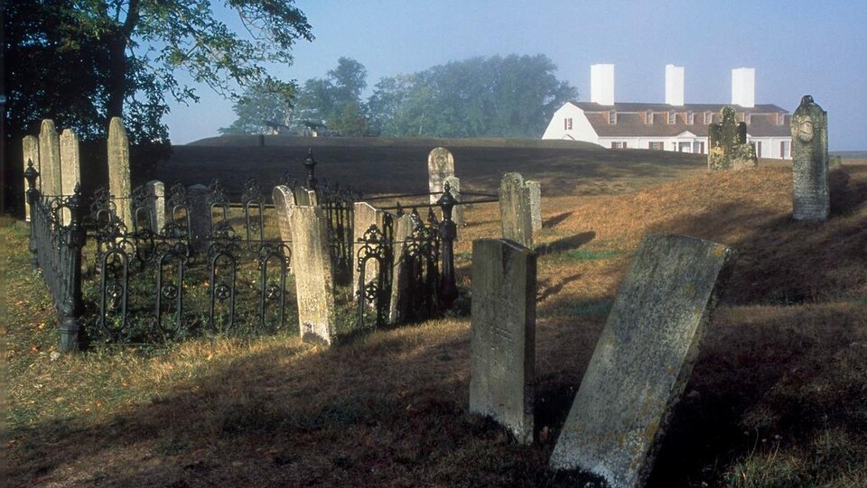 Des pierres tombales décrépites près d'une ferme.