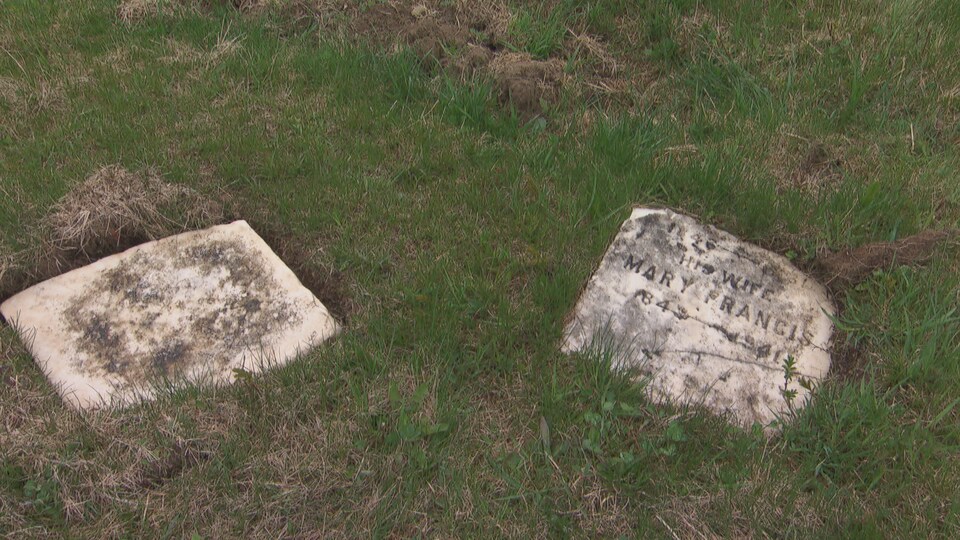 Deux pierres tombales retrouvées dans le cimetière de la Mission Sainte-Anne, samedi.